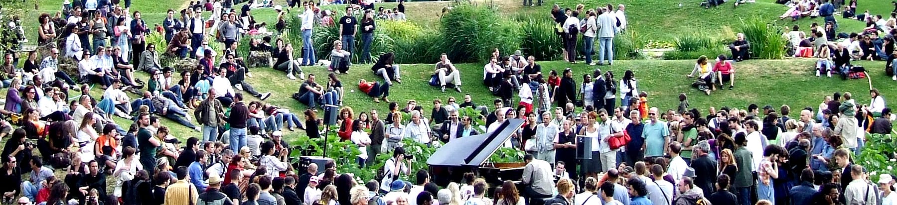 Concert en plein air, public installé dans l'herbe autour du piano